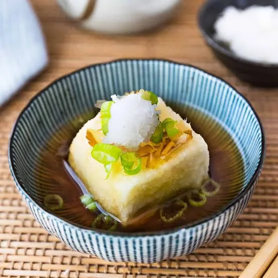 Bowl of golden fried tofu in dashi broth topped with grated radish and spring onion