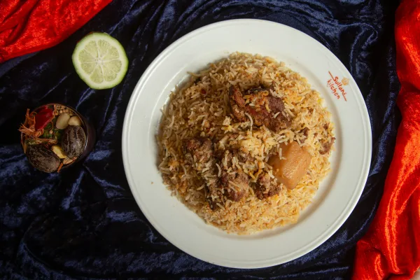 Pot of Pakistani beef biryani with saffron rice, tender beef, potatoes, fried onions and fresh mint