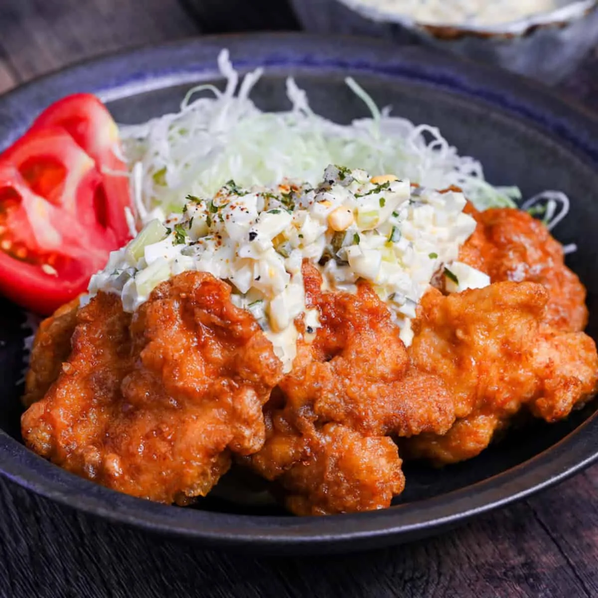 Sliced fried chicken nanban topped with creamy tartar sauce on shredded cabbage, served with rice