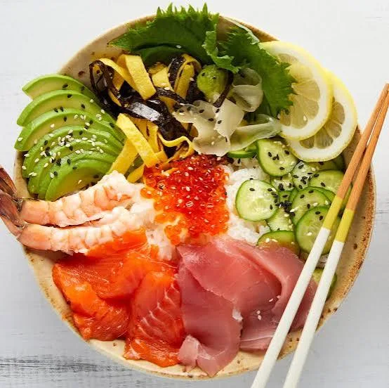 Chirashi sushi bowl topped with salmon, prawns, egg ribbons, cucumber and avocado over sushi rice