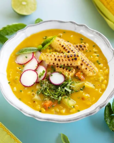 Bowl of creamy corn chowder with corn kernels, potato and spring onion garnish