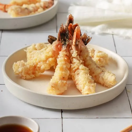 Golden crisp ebi tempura prawns served with dipping sauce, grated radish and lemon wedges