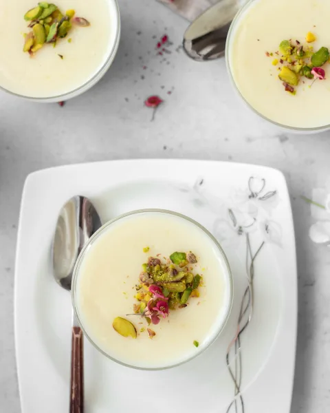 Terracotta bowls of chilled firni topped with pistachios, almonds and saffron