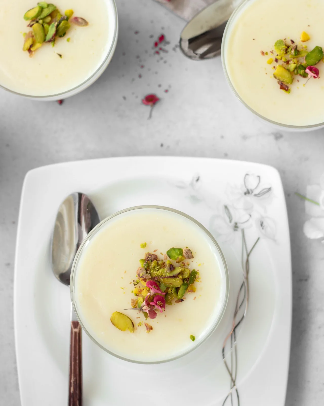 Terracotta bowls of chilled firni topped with pistachios, almonds and saffron