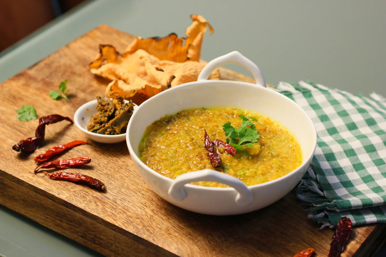 Bowl of lauki chana daal with bottle gourd cubes, cumin and red chilli tarka and fresh coriander, served with rice and roti
