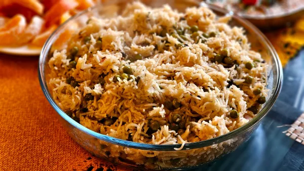 Fluffy basmati rice with green peas and fried onions in a serving pot