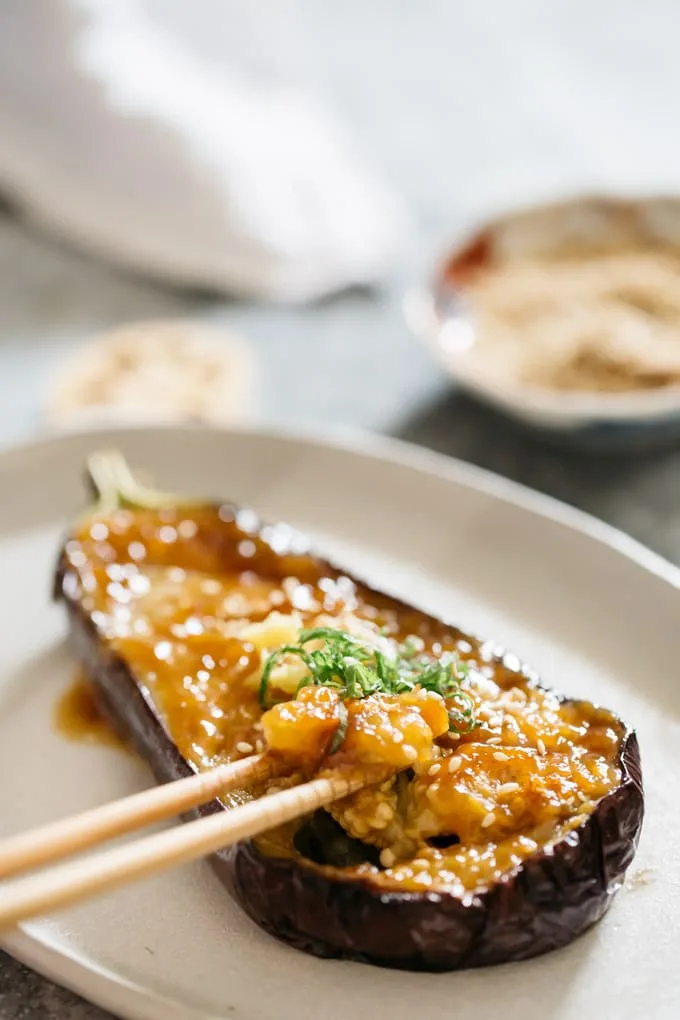 Miso-glazed aubergine halves topped with sesame seeds and spring onions, served with steamed rice
