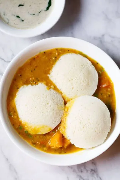 Plate of soft white steamed idlis served with coconut chutney and sambar