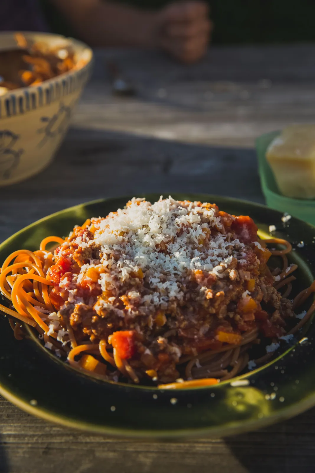 A bowl of spaghetti topped with rich beef and tomato Bolognese sauce, grated Parmesan and fresh basil