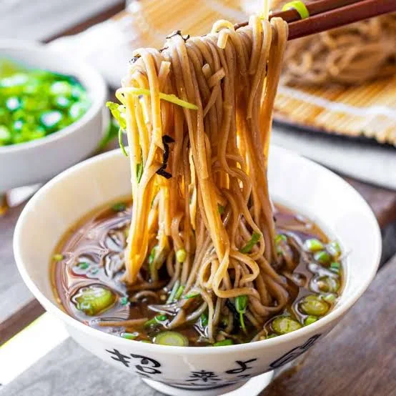 Cold soba noodles on a bamboo tray with nori, dipping sauce, wasabi, ginger and spring onions
