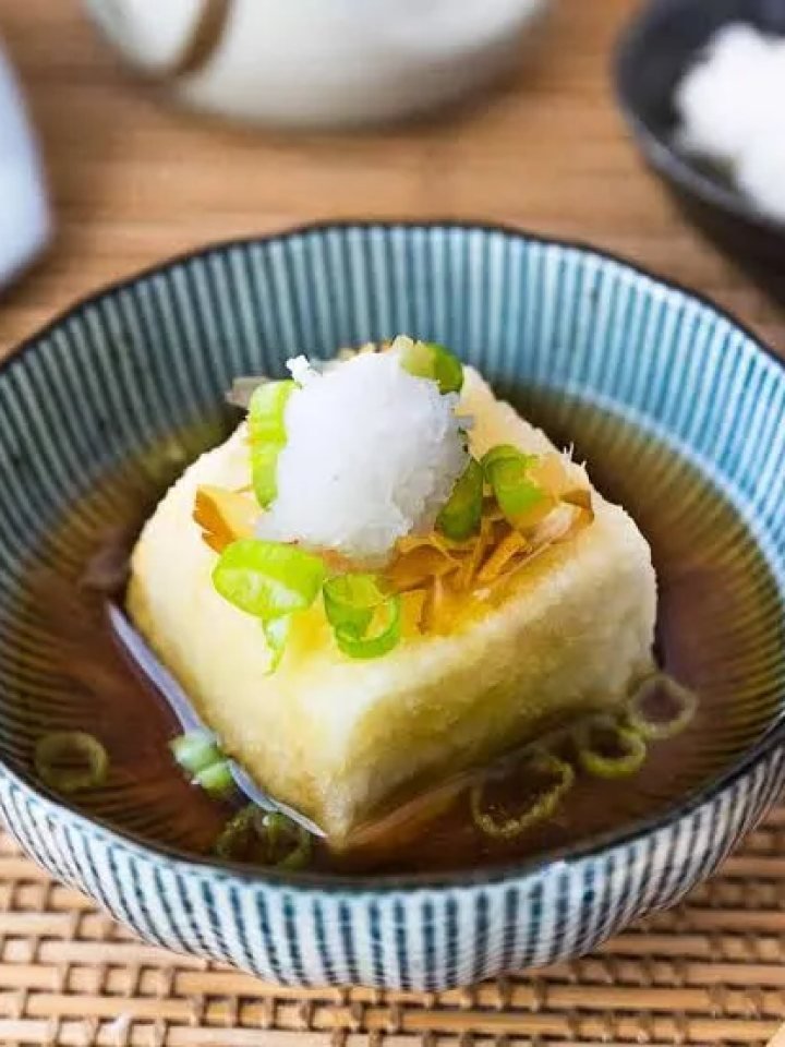 Bowl of golden fried tofu in dashi broth topped with grated radish and spring onion