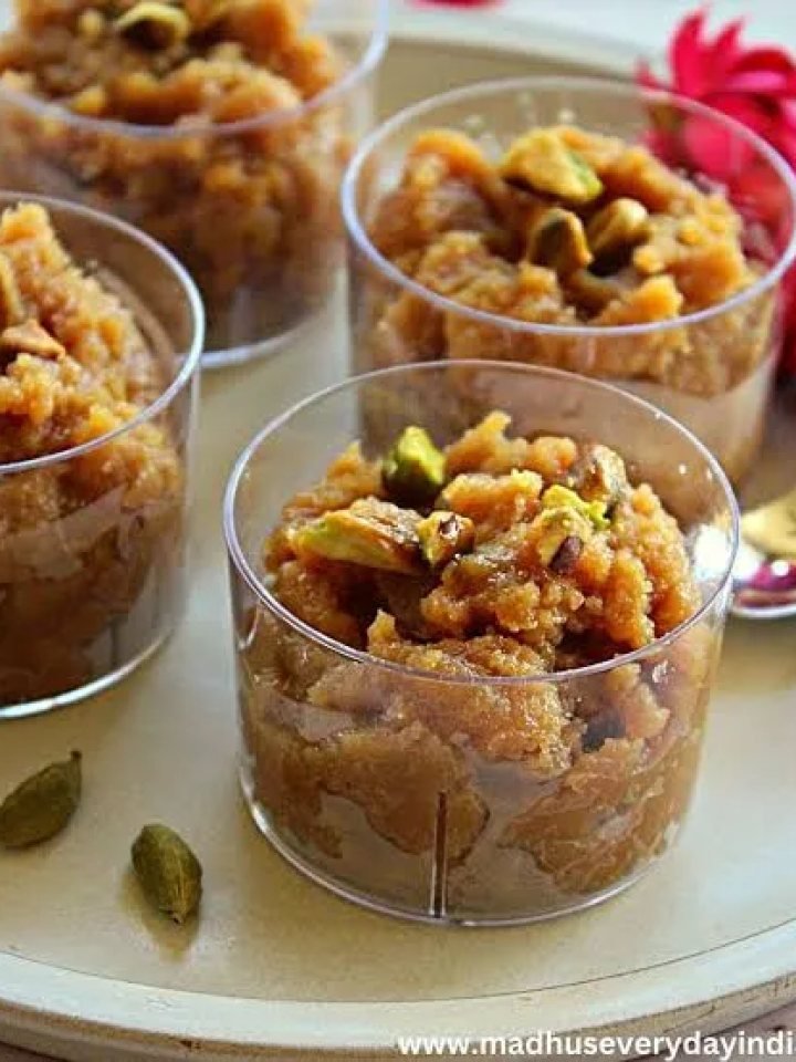 Glossy golden almond halwa in a brass dish garnished with pistachios, flaked almonds and saffron