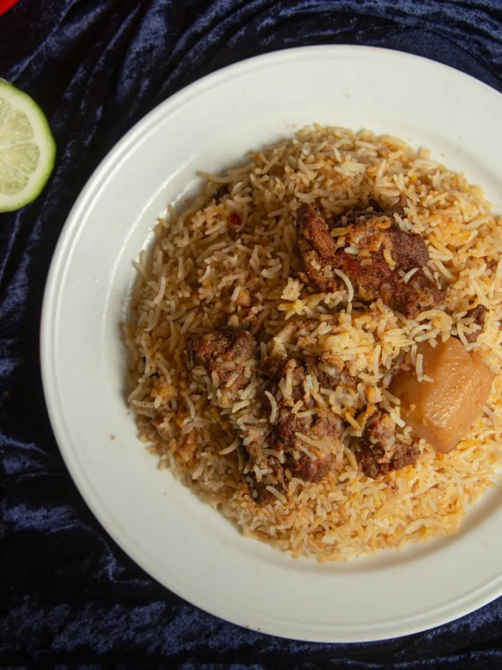 Pot of Pakistani beef biryani with saffron rice, tender beef, potatoes, fried onions and fresh mint