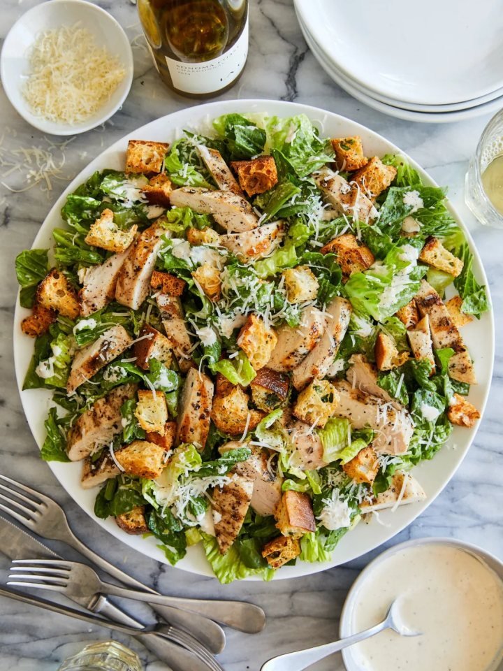 Bowl of chicken Caesar salad with sliced chicken, romaine, croutons and parmesan
