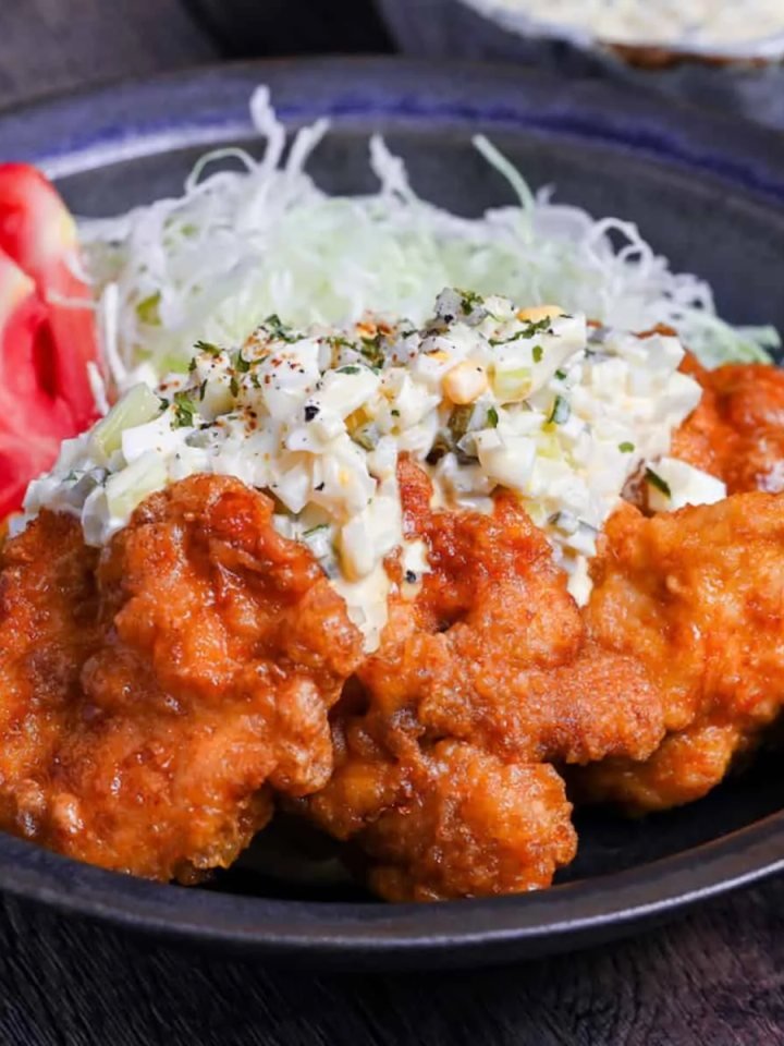 Sliced fried chicken nanban topped with creamy tartar sauce on shredded cabbage, served with rice