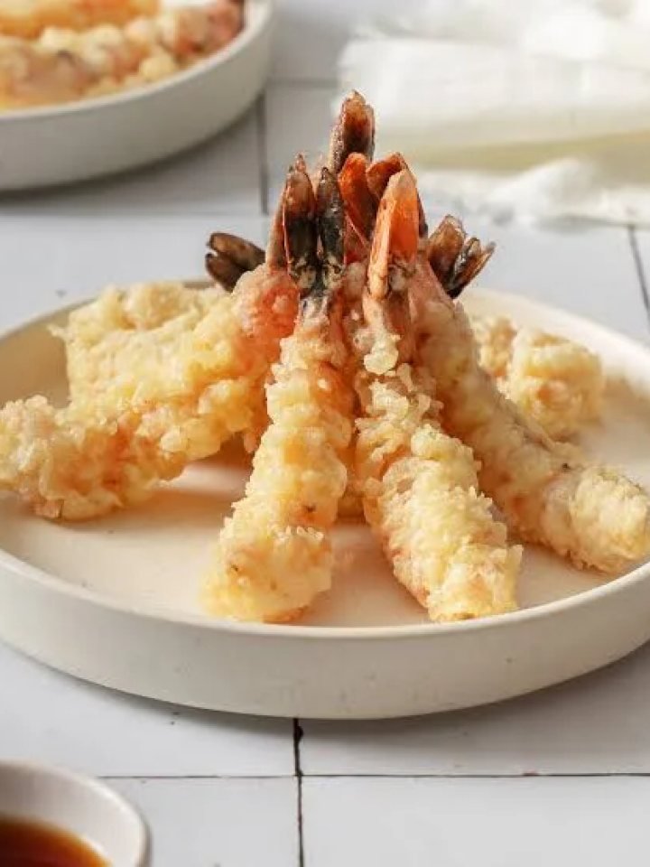 Golden crisp ebi tempura prawns served with dipping sauce, grated radish and lemon wedges