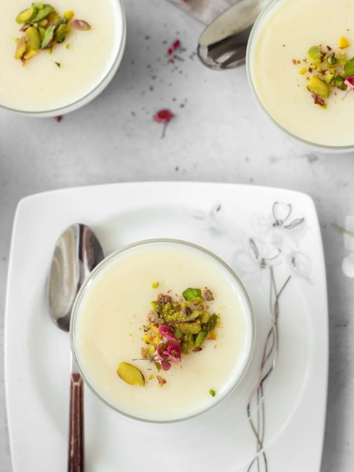 Terracotta bowls of chilled firni topped with pistachios, almonds and saffron