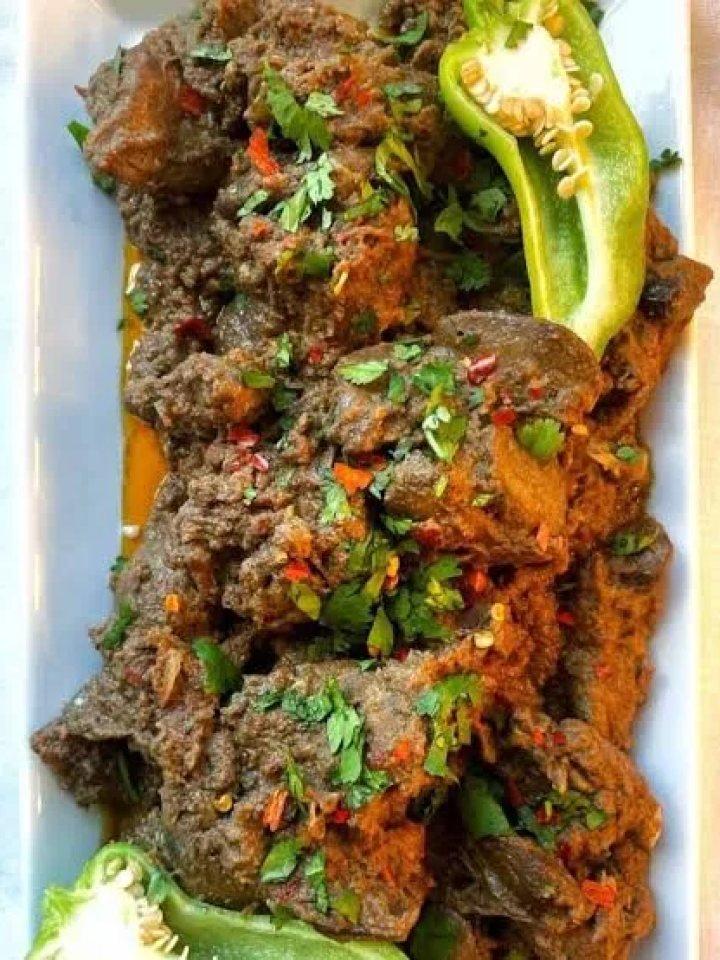 A karahi of Pakistani kaleji masala with liver cubes in thick masala, garnished with ginger, green chilli and coriander
