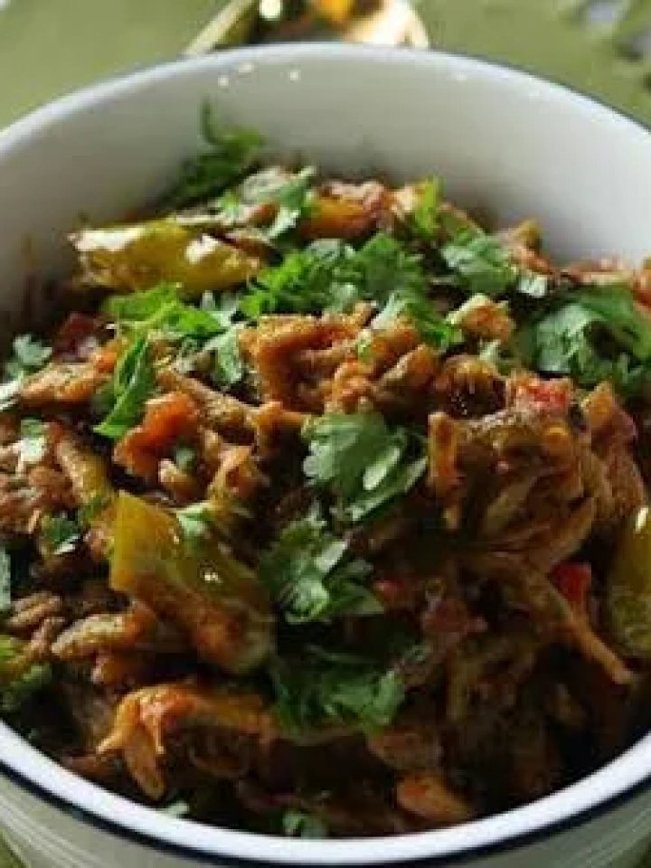 Pan of karelay pyaz with browned bitter gourd rounds, golden onions and green chillies, served with chapatis