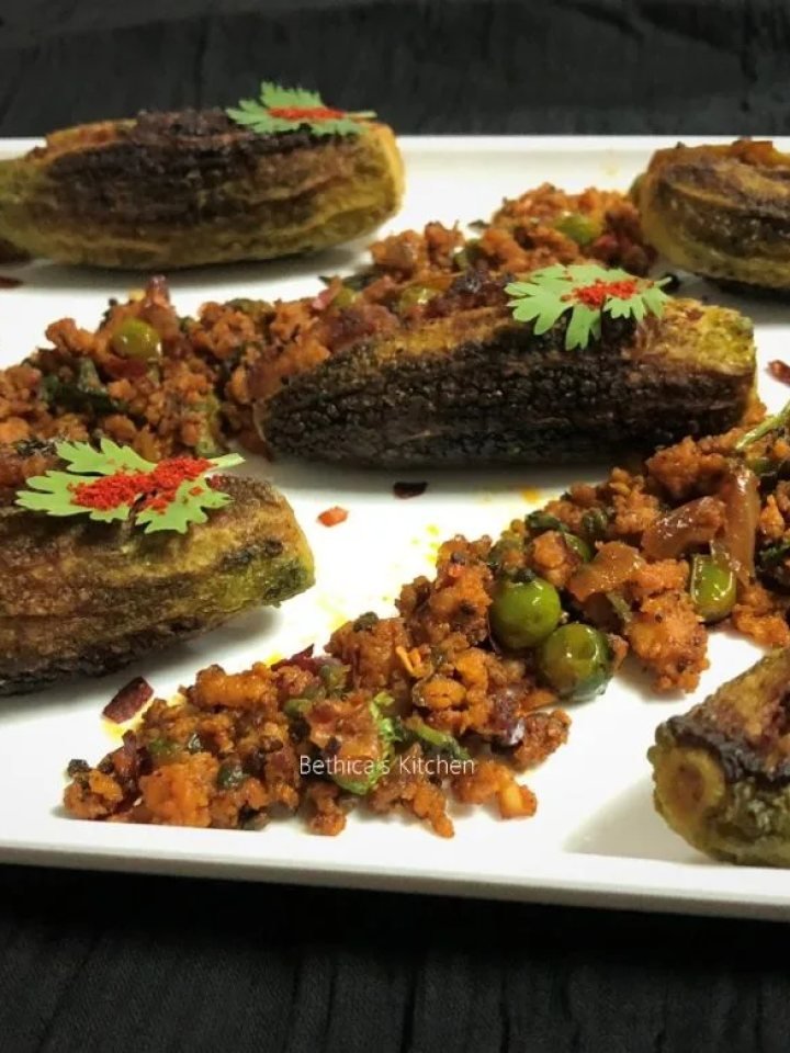 A karahi of keema karela with browned bitter gourd pieces in spiced beef mince, topped with coriander and ginger