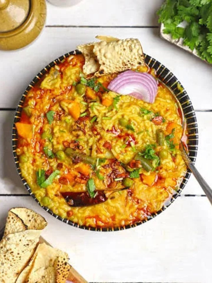 A bowl of golden moong daal khichdi topped with melted ghee, fried garlic and coriander