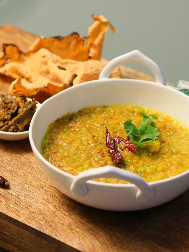 Bowl of lauki chana daal with bottle gourd cubes, cumin and red chilli tarka and fresh coriander, served with rice and roti