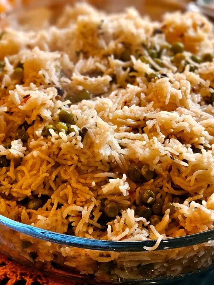 Fluffy basmati rice with green peas and fried onions in a serving pot