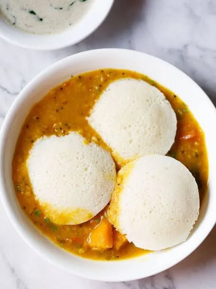 Plate of soft white steamed idlis served with coconut chutney and sambar