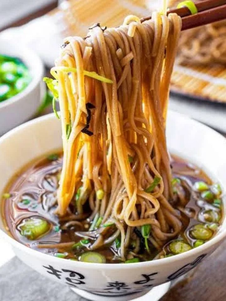 Cold soba noodles on a bamboo tray with nori, dipping sauce, wasabi, ginger and spring onions